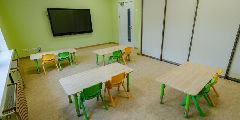 Bērnudārza grupas telpa ar galdiņiem un krēsliņiem