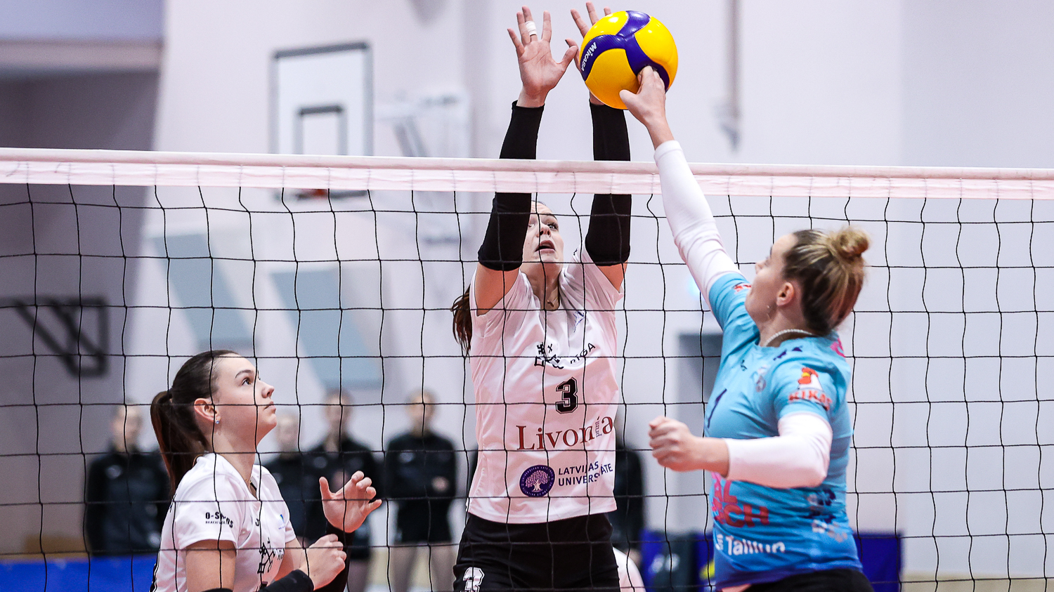 RVS/LU volejbola komandas spēlētāju cīņa pie tīkla ar Taltech komandu